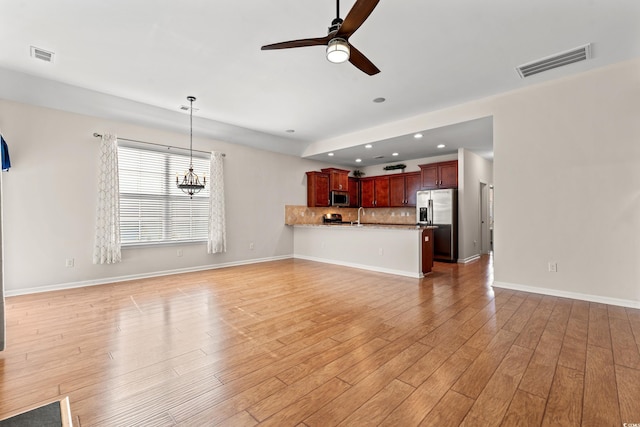 unfurnished living room featuring ceiling fan, sink, and light hardwood / wood-style floors