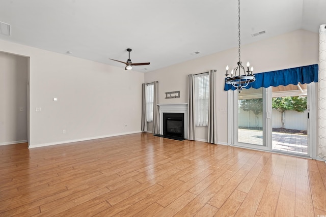 unfurnished living room with ceiling fan with notable chandelier and light hardwood / wood-style flooring