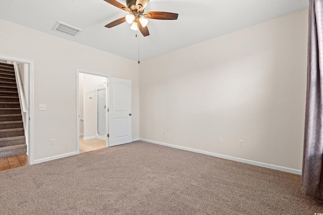 unfurnished bedroom with carpet flooring, a walk in closet, a closet, and ceiling fan