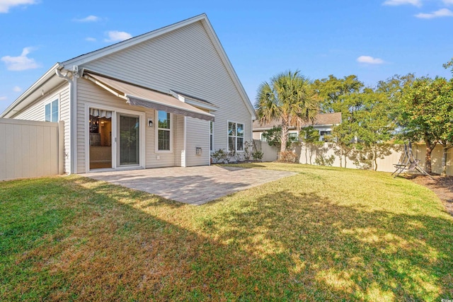 rear view of house featuring a lawn and a patio area