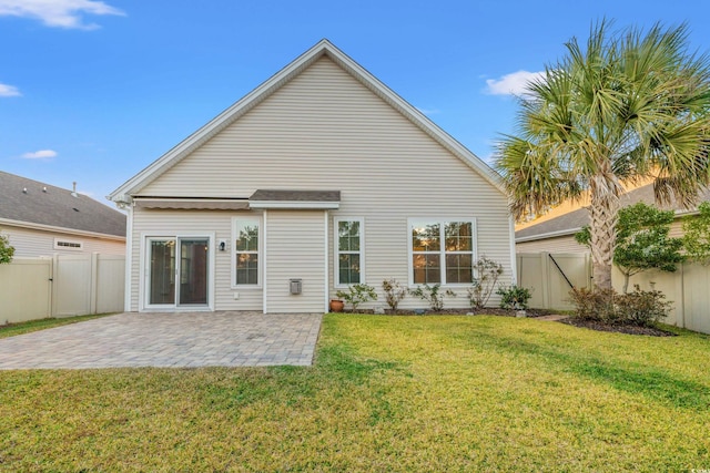 rear view of house featuring a patio area and a lawn