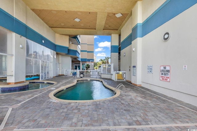 community pool featuring a patio area and fence