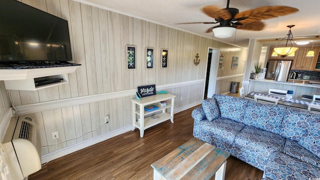 living room with dark hardwood / wood-style floors, ceiling fan, and crown molding