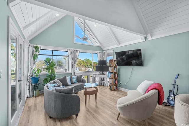 living room featuring a wealth of natural light, beamed ceiling, light hardwood / wood-style floors, and high vaulted ceiling