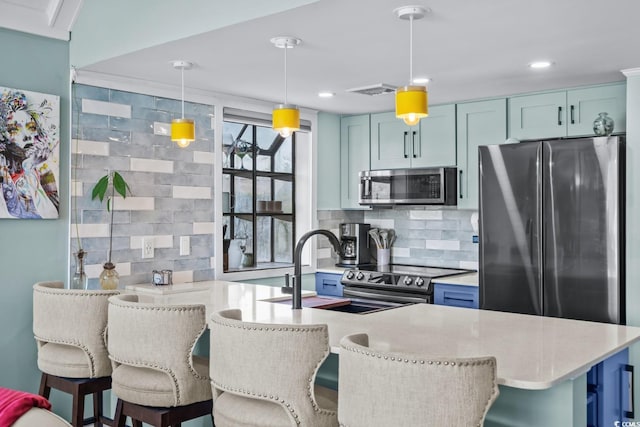 kitchen featuring decorative backsplash, a kitchen bar, hanging light fixtures, and appliances with stainless steel finishes