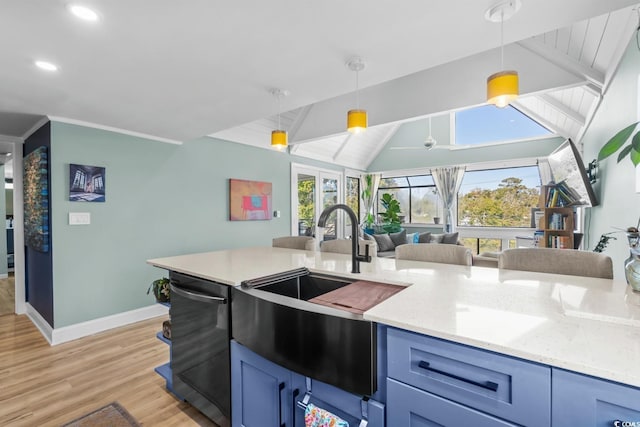 kitchen featuring ceiling fan, sink, light hardwood / wood-style flooring, lofted ceiling with beams, and decorative light fixtures