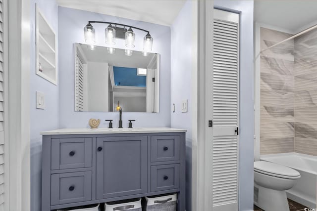 full bathroom with tiled shower / bath, vanity, and toilet