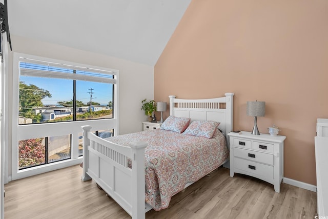 bedroom with lofted ceiling and light hardwood / wood-style flooring