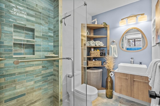 bathroom featuring vanity, toilet, and a shower with shower door