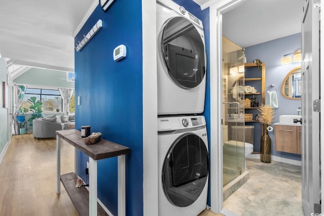 washroom featuring stacked washing maching and dryer and hardwood / wood-style flooring