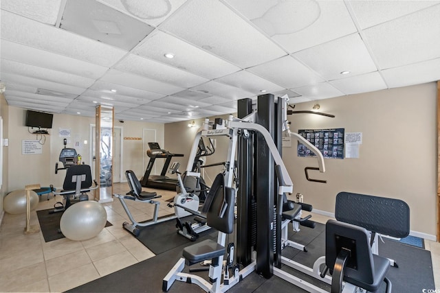 workout area featuring tile patterned flooring and a drop ceiling