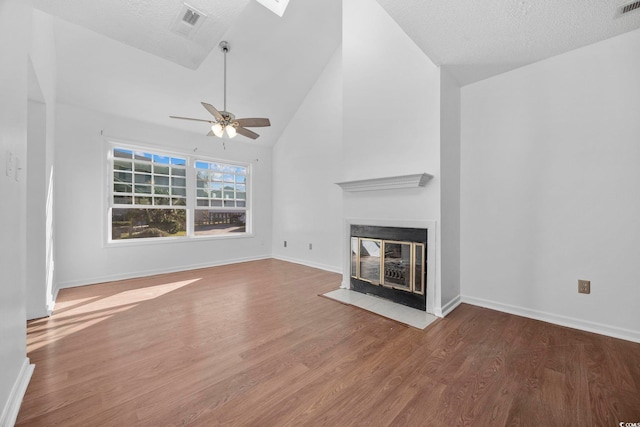 unfurnished living room with wood-type flooring, a textured ceiling, high vaulted ceiling, and ceiling fan