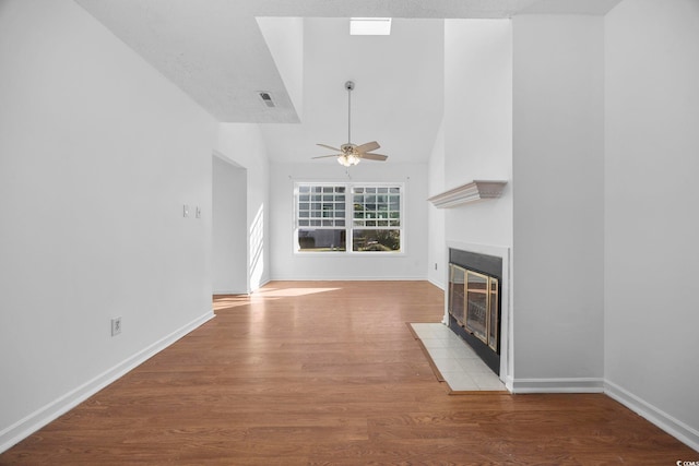 unfurnished living room with a tile fireplace, a textured ceiling, hardwood / wood-style flooring, and ceiling fan