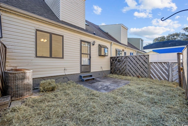 rear view of house featuring cooling unit and a lawn