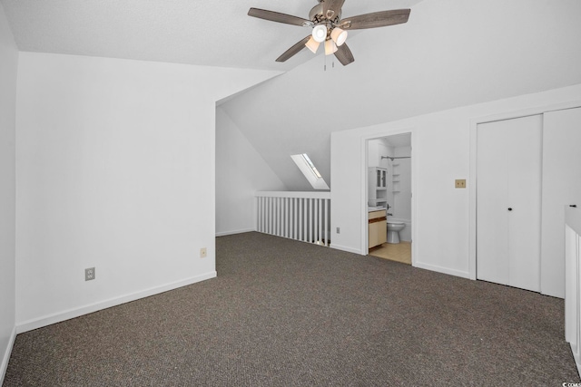 additional living space featuring dark colored carpet, ceiling fan, and lofted ceiling