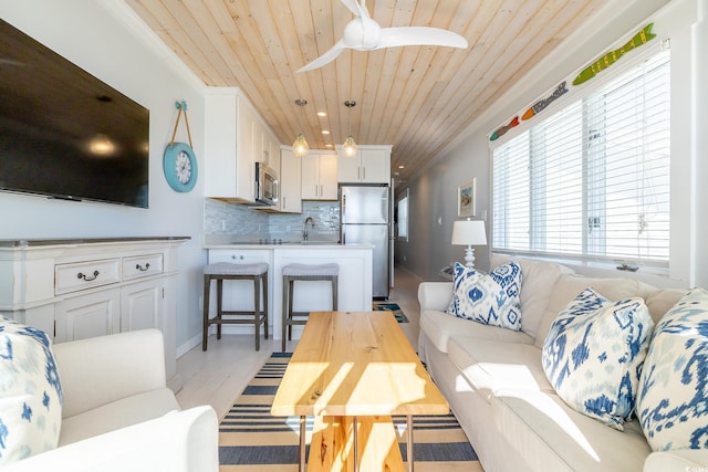 living room with ceiling fan, sink, wooden ceiling, and light wood-type flooring