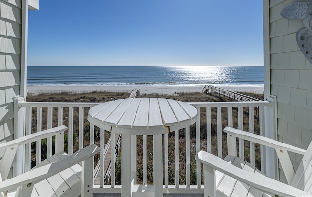 balcony featuring a water view and a view of the beach