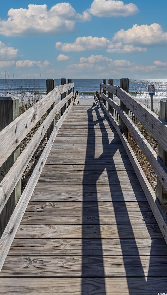 dock area with a beach view and a water view