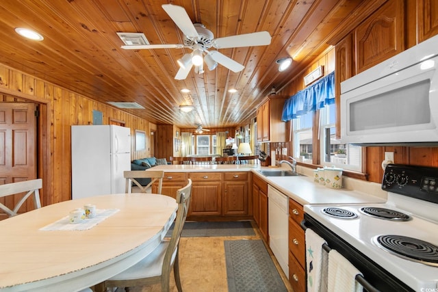 kitchen with kitchen peninsula, white appliances, wooden walls, and wood ceiling