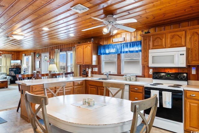 kitchen featuring wood walls, white appliances, sink, and wooden ceiling