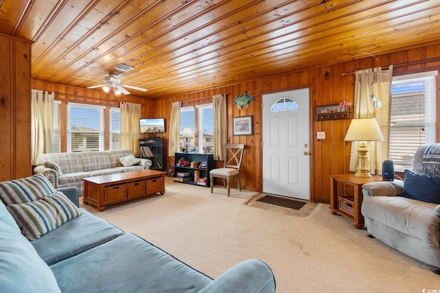 living room featuring a wealth of natural light, wooden walls, light colored carpet, and wooden ceiling