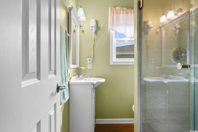 bathroom featuring vanity, toilet, wood-type flooring, and a shower with shower door