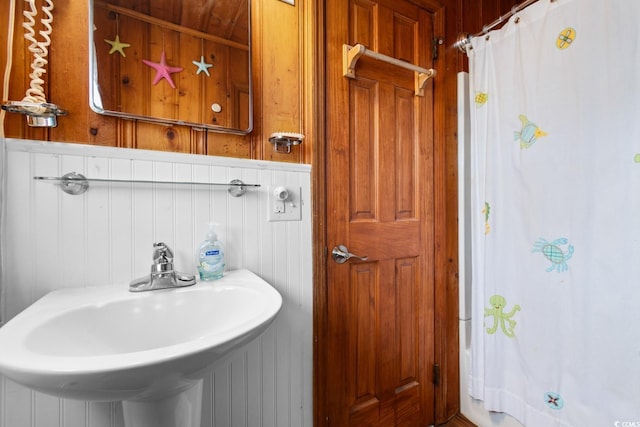 bathroom with sink and wooden walls