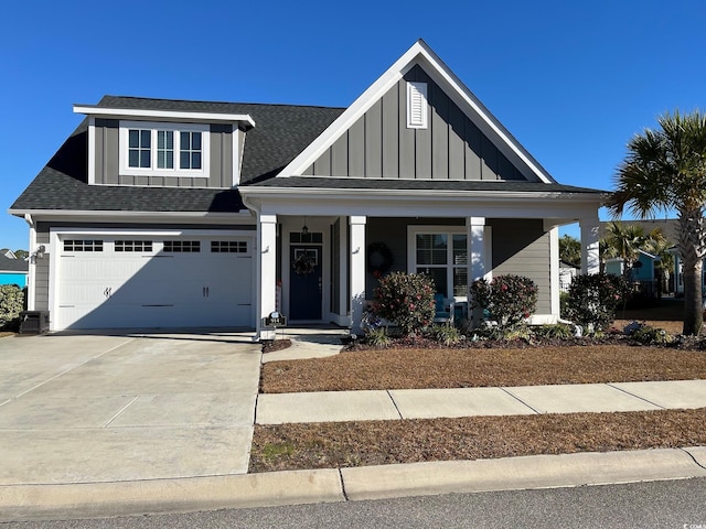 view of front of home featuring roof with shingles, a porch, concrete driveway, an attached garage, and board and batten siding