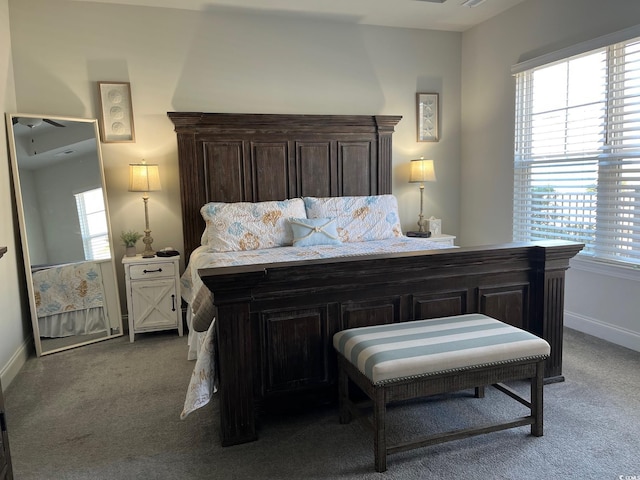 carpeted bedroom featuring multiple windows and baseboards