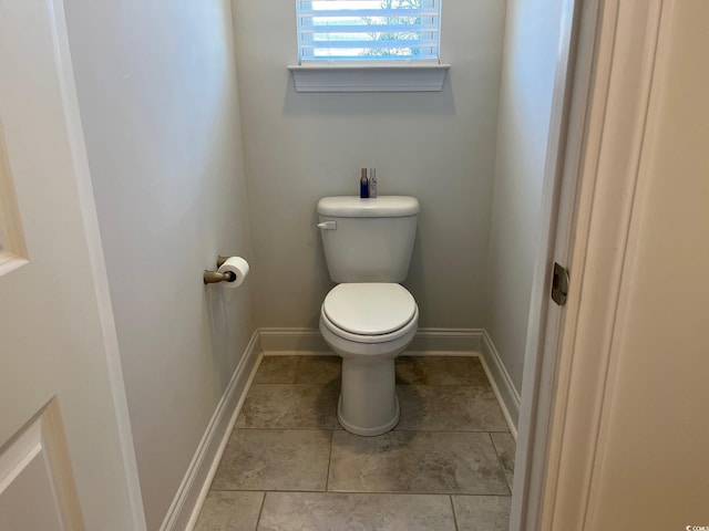 bathroom featuring toilet and baseboards