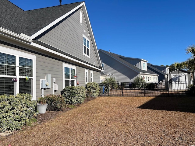 exterior space featuring a shingled roof and fence