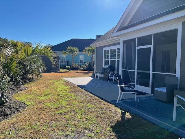 view of yard featuring a sunroom and a patio