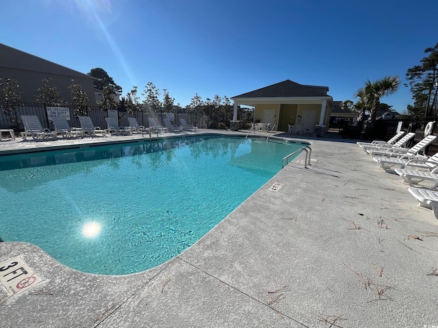 community pool featuring a patio area and fence