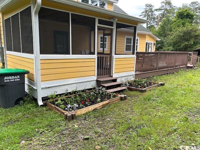 2708 Main St, Loris, SC 29569 - view of side of property featuring a garden, a yard, a sunroom, and a deck