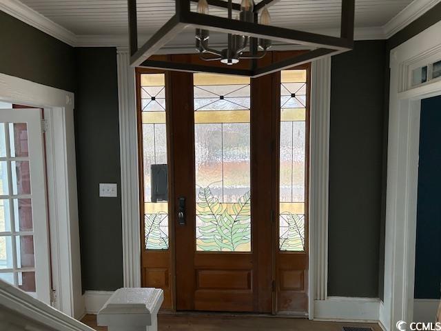 doorway to outside featuring a wealth of natural light and a chandelier