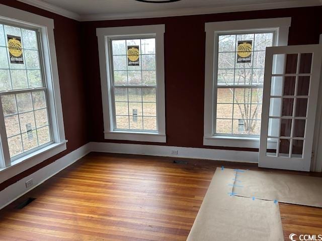 unfurnished dining area with crown molding and light hardwood / wood-style floors