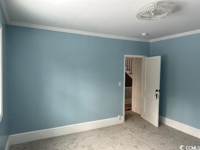 spare room featuring ornamental molding and light carpet