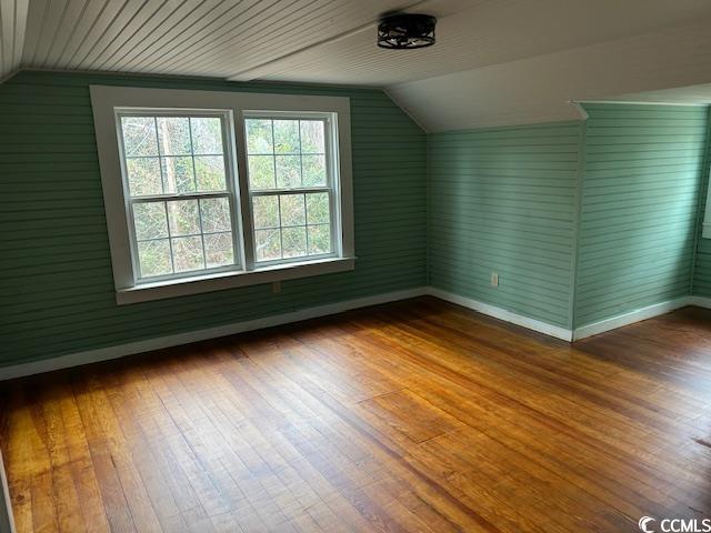 additional living space with lofted ceiling and wood-type flooring