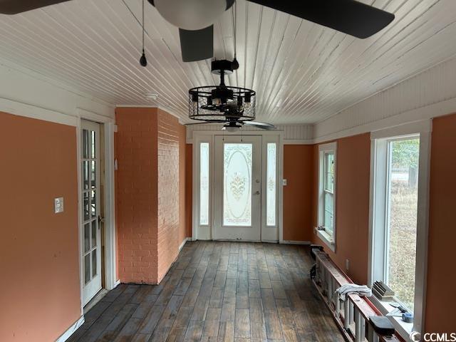 entrance foyer featuring dark hardwood / wood-style flooring, brick wall, and ceiling fan