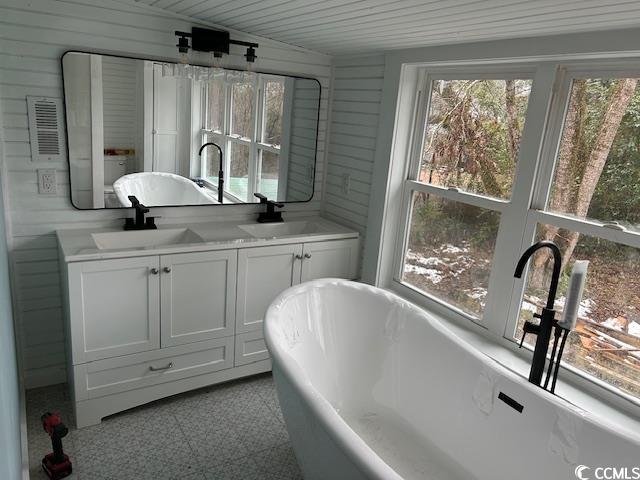 2708 Main St, Loris, SC 29569 - bathroom featuring a soaking tub, double vanity, wooden ceiling, wooden walls, and tile patterned floors