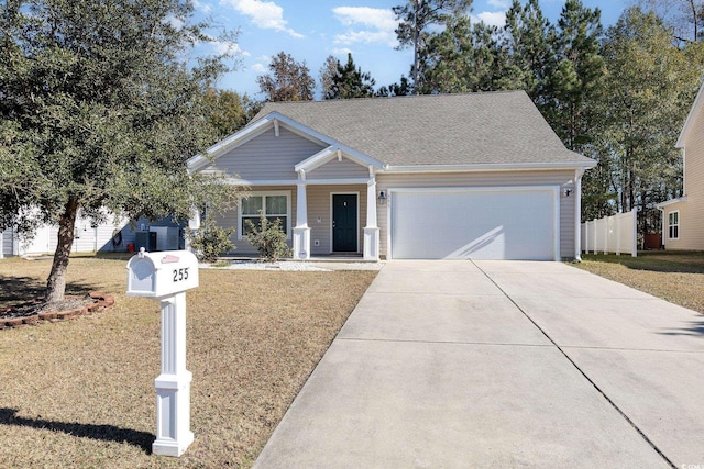 view of front facade featuring a yard, central AC unit, and a garage