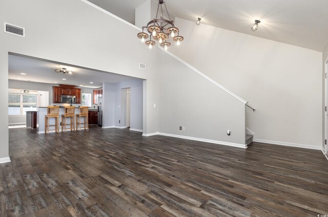 unfurnished living room with a notable chandelier, dark hardwood / wood-style floors, and high vaulted ceiling