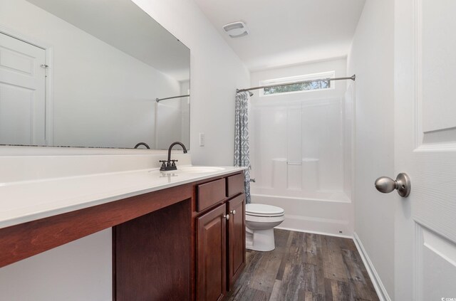 full bathroom with hardwood / wood-style floors, vanity, toilet, and shower / bath combo with shower curtain