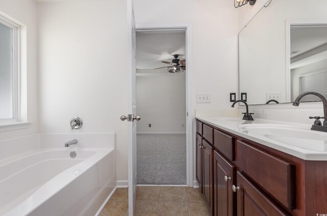 bathroom featuring tile patterned floors, a tub, ceiling fan, and vanity