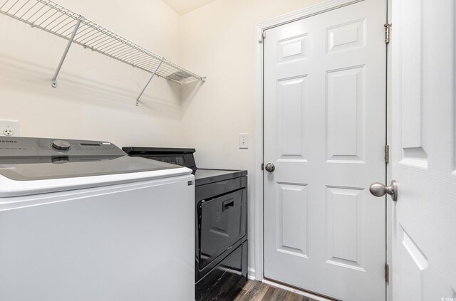 laundry room with washer and dryer and dark hardwood / wood-style floors