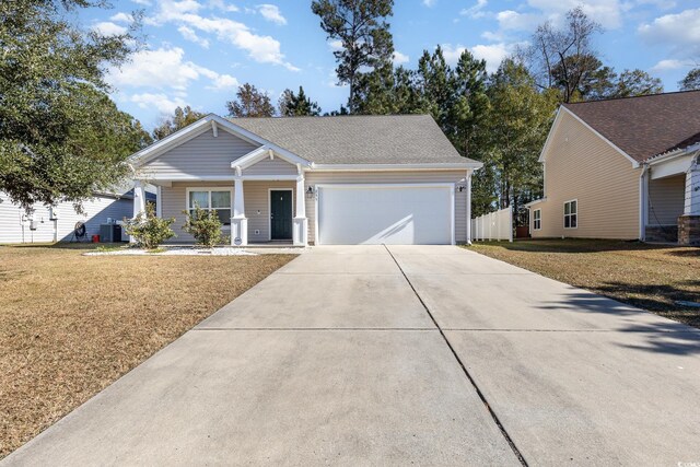 view of front of home featuring a front yard, a garage, central AC unit, and covered porch