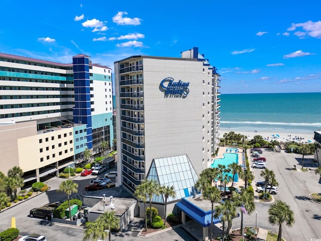 view of building exterior featuring a water view and a view of the beach