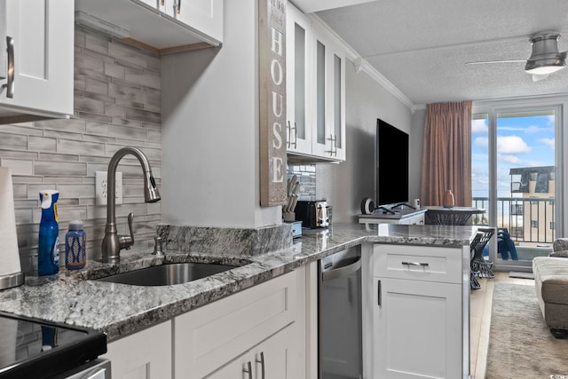 kitchen featuring dishwasher, kitchen peninsula, white cabinetry, and sink