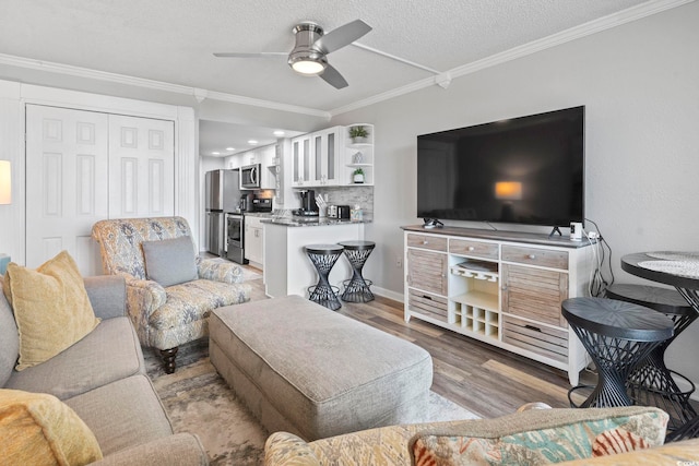 living room featuring a textured ceiling, light hardwood / wood-style flooring, ceiling fan, and ornamental molding