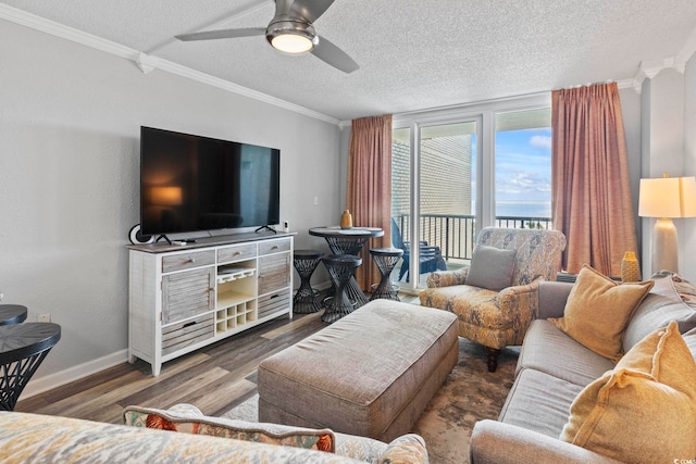 living room with ceiling fan, dark wood-type flooring, a textured ceiling, and ornamental molding